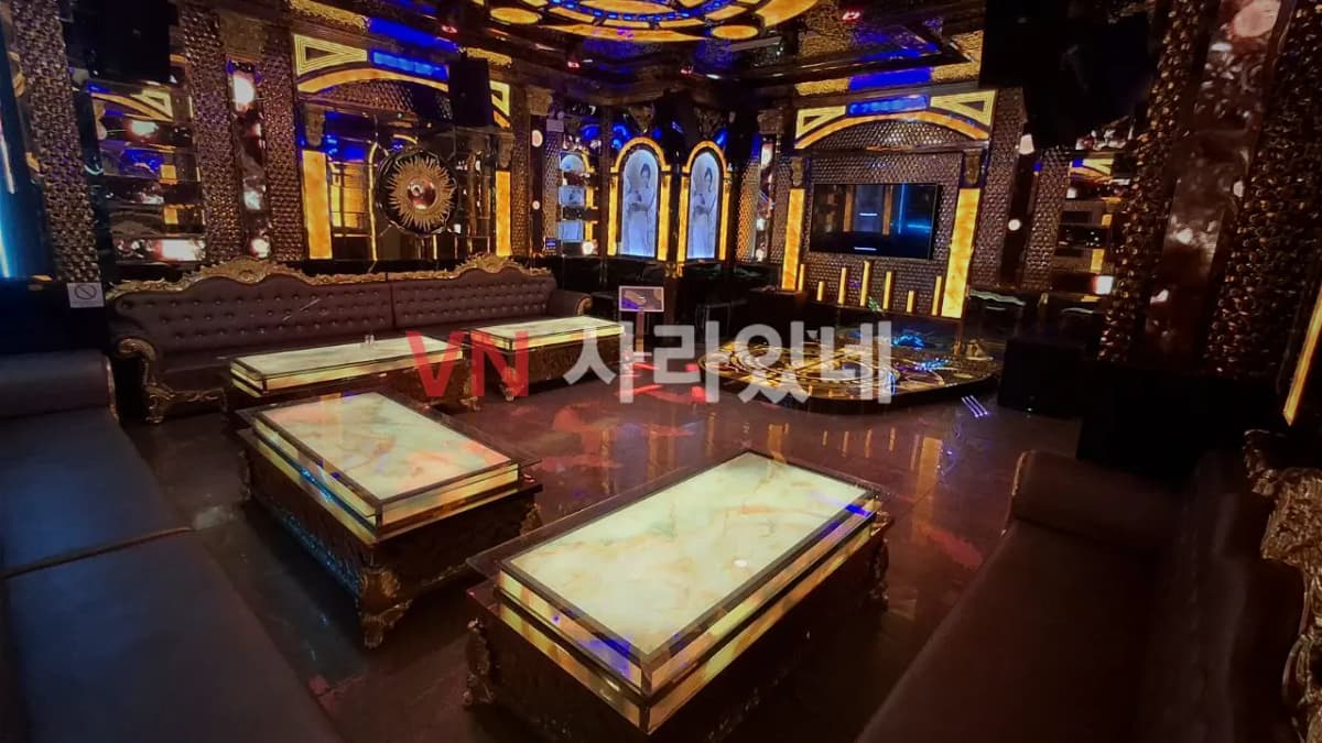나트랑 아노바 가라오케 대형 로열 골드 VIP 룸 — 대리석 조명 테이블과 클래식 가죽 소파