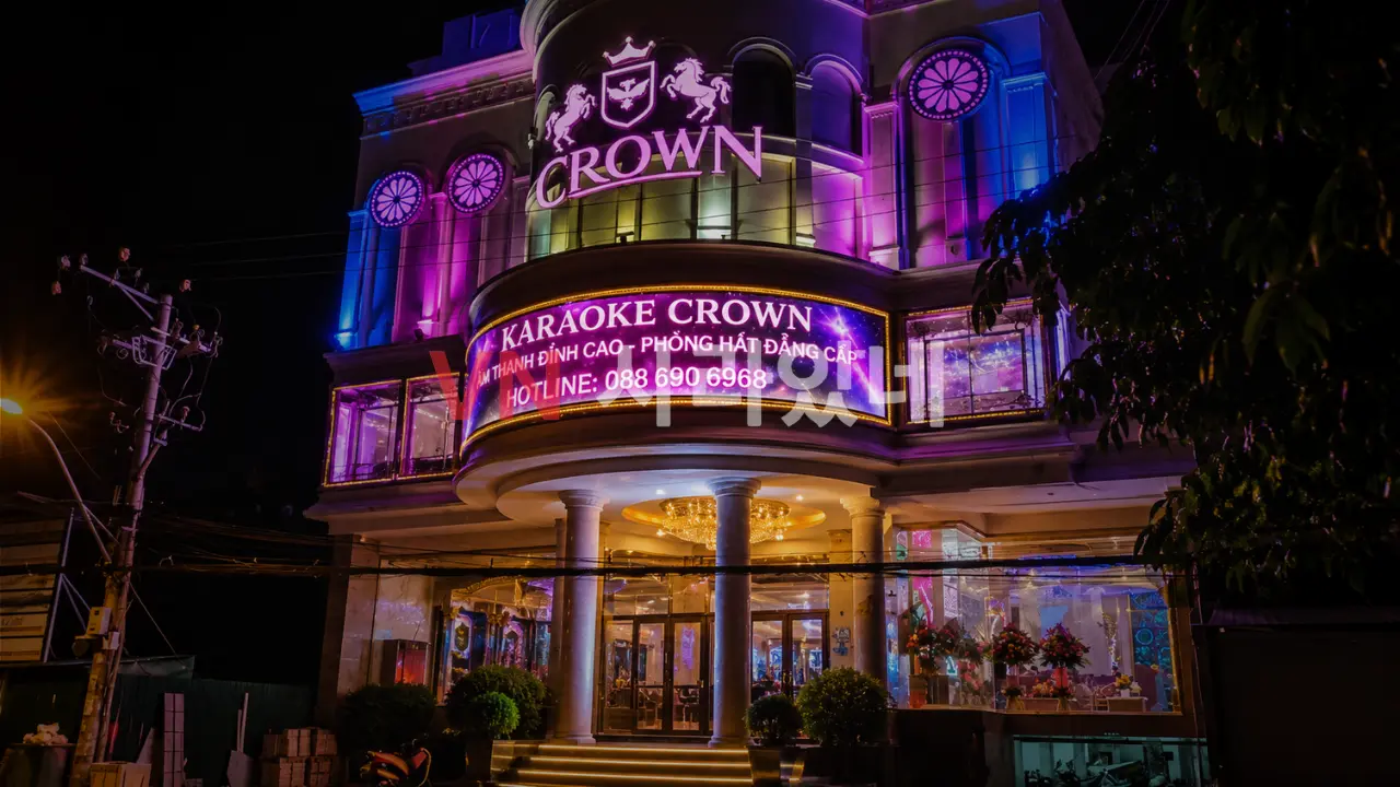나트랑 크라운 가라오케 야경 외관 — CROWN KARAOKE 대형 전광판·보라·파란 LED 조명 건물 전경