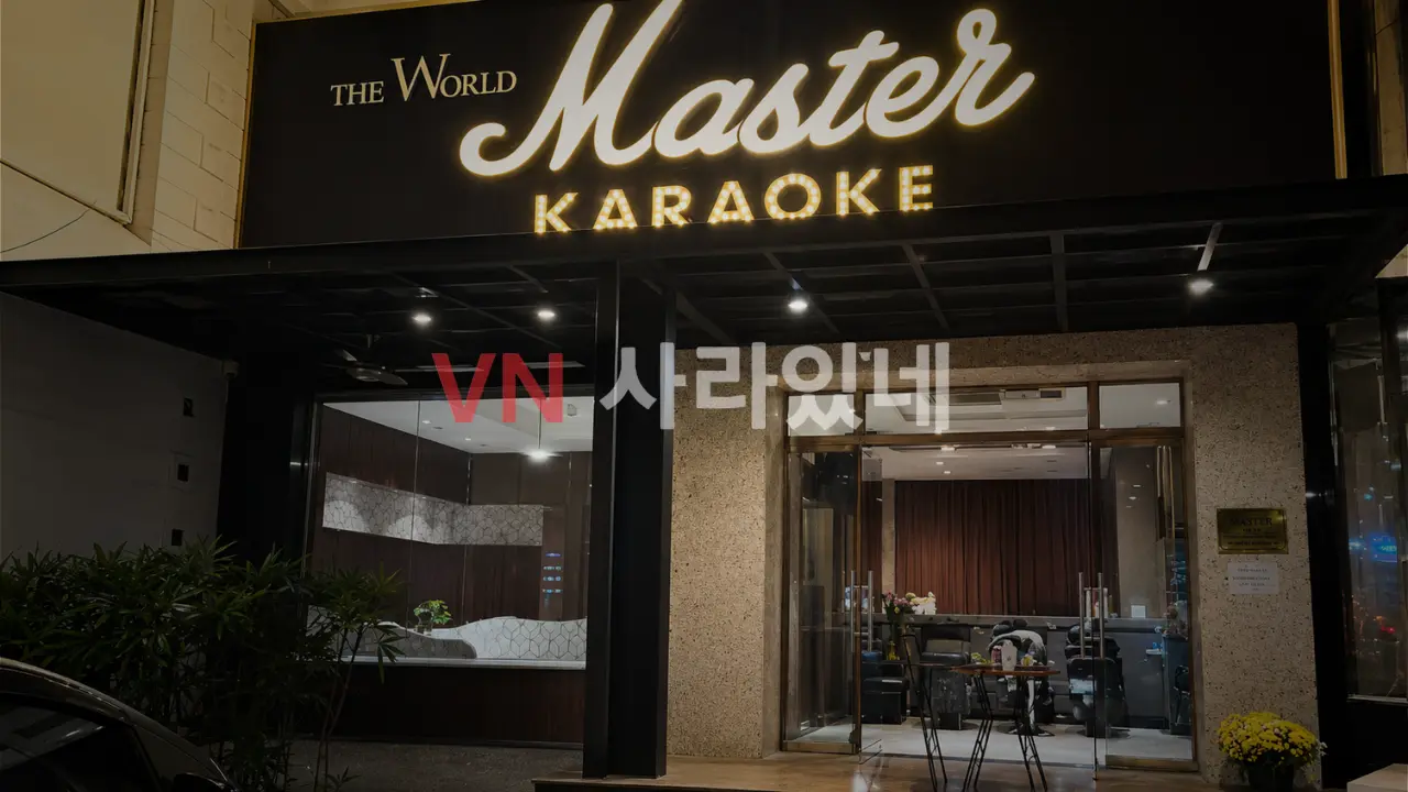 나트랑 마스터 가라오케 야간 외관 — THE WORLD MASTER KARAOKE 골드 간판·유리 입구·황금 국화 장식
